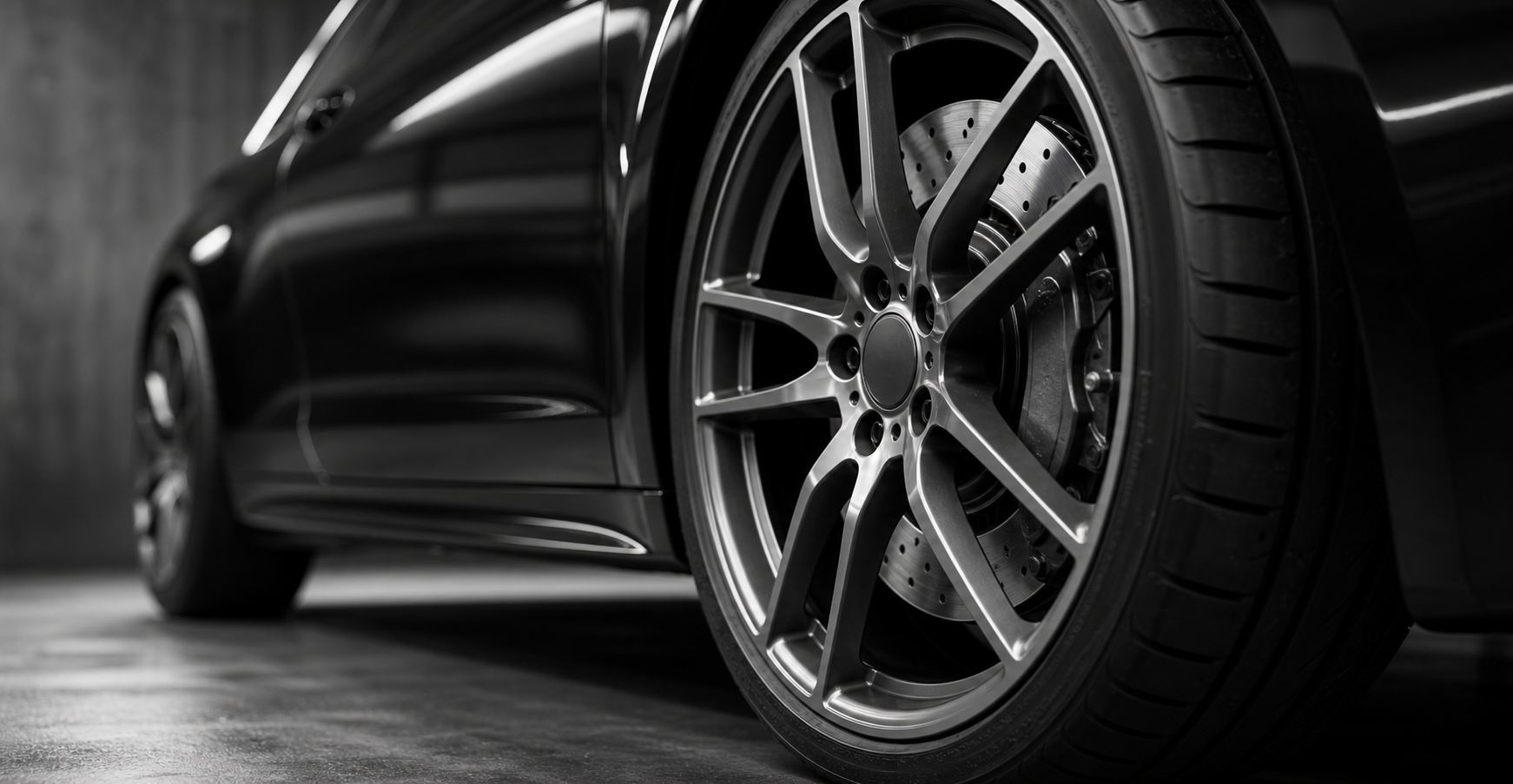 Monochrome close-up of an unbranded wheel and brake detail.
